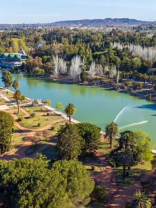 Aerial view of the lake and trees in Parque General San Martin under the blue sky